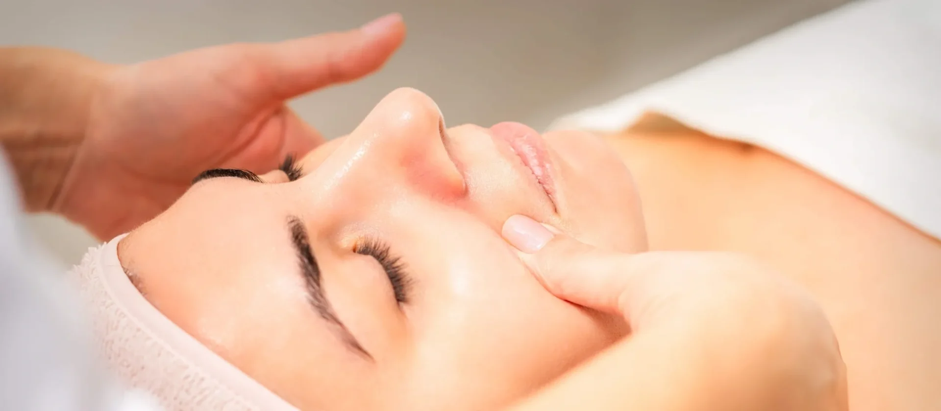 A woman getting her face washed with lotion.