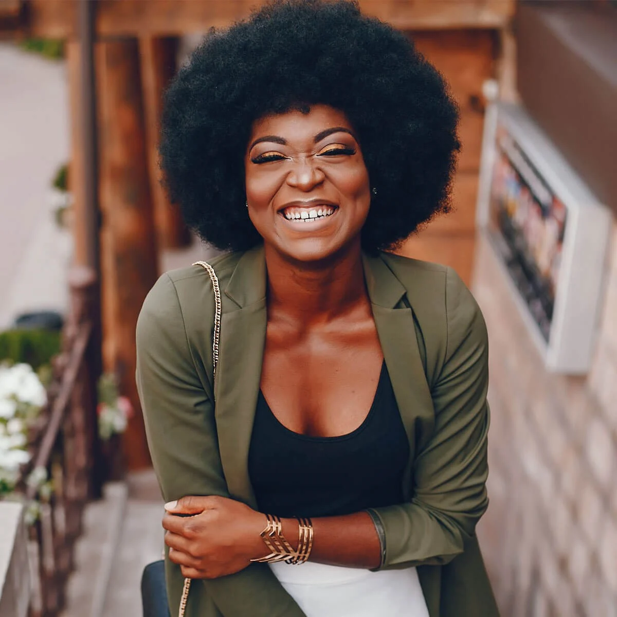 A woman with afro hair smiling for the camera.