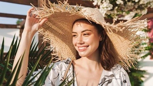 A woman wearing a hat and smiling for the camera.