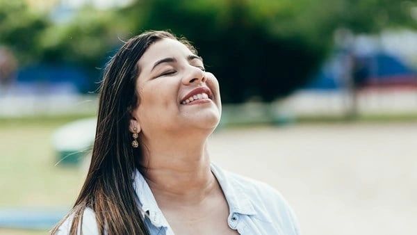 A woman smiling with her eyes closed.