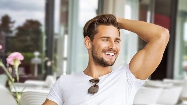 A man with beard and sunglasses smiling for the camera.