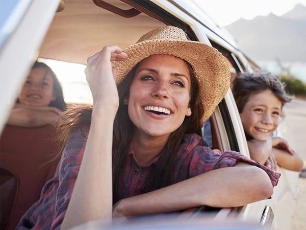 A woman in the back of a car with two other women.