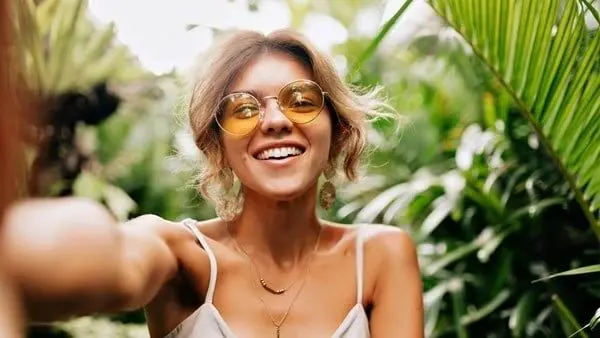 A woman with glasses smiling for the camera.