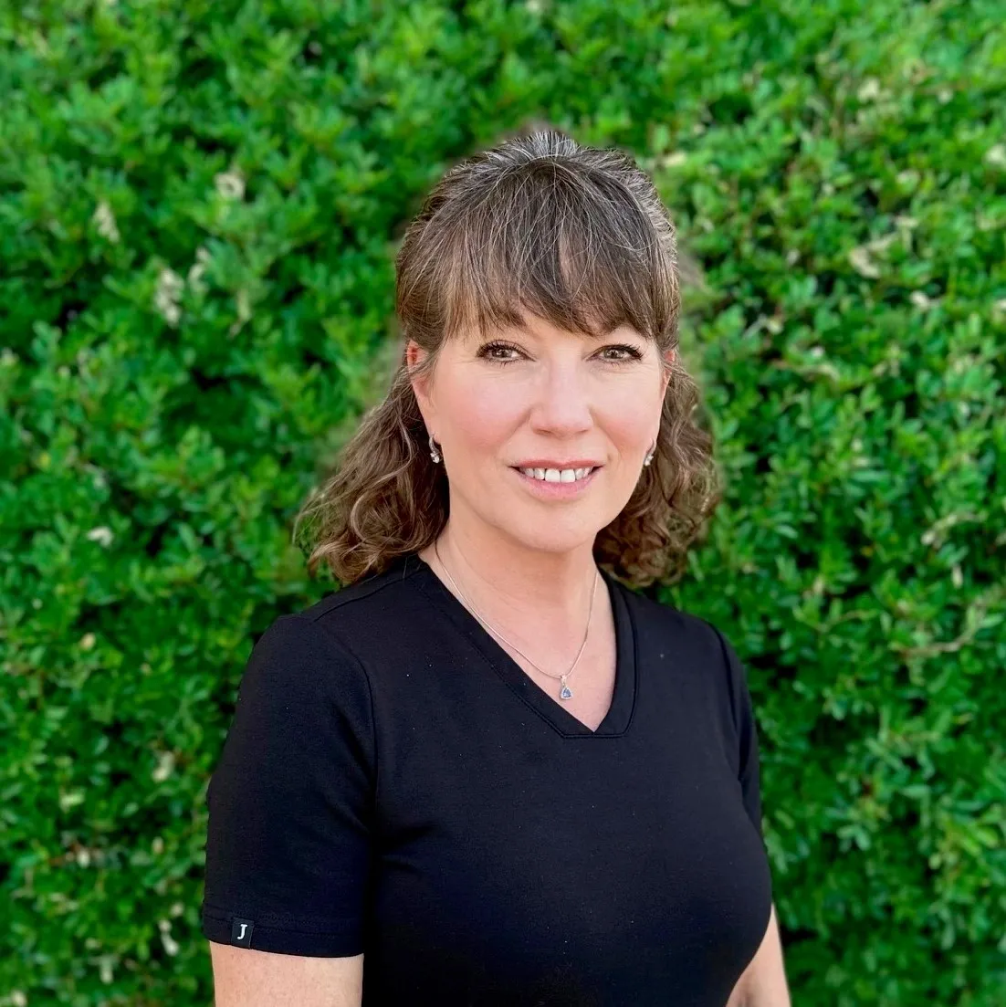 A woman standing in front of a green wall.