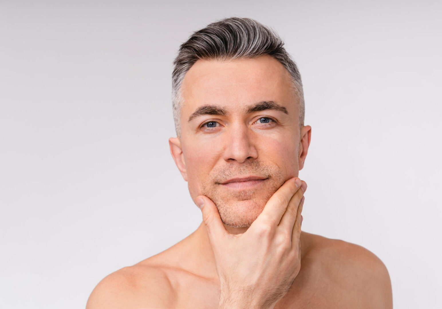 A man with grey hair is posing for the camera.