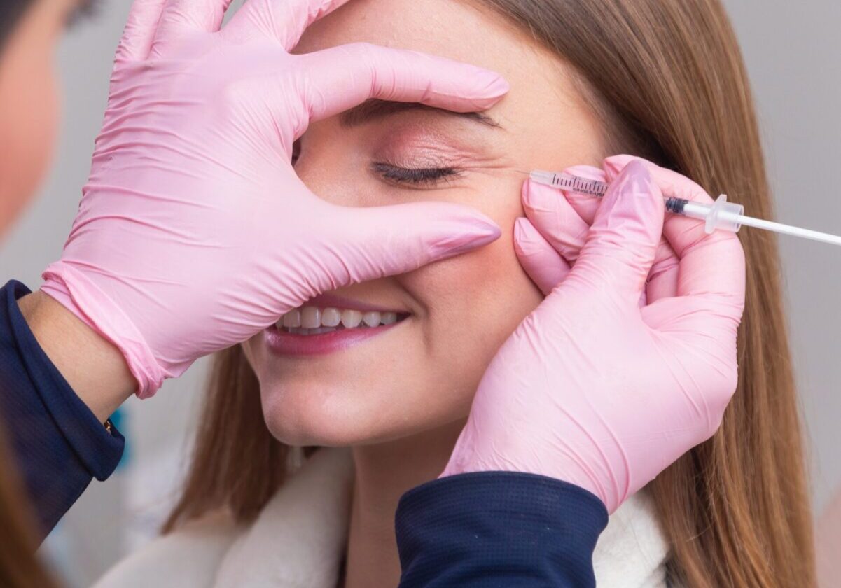 A woman getting her face waxed by an esthetician.